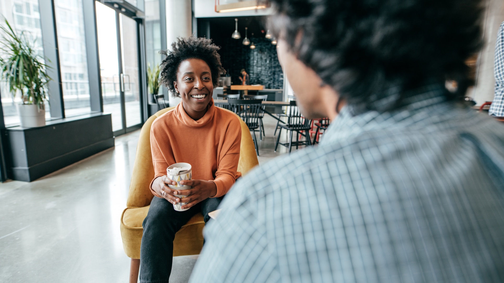 A team leader coaching an agent over coffee